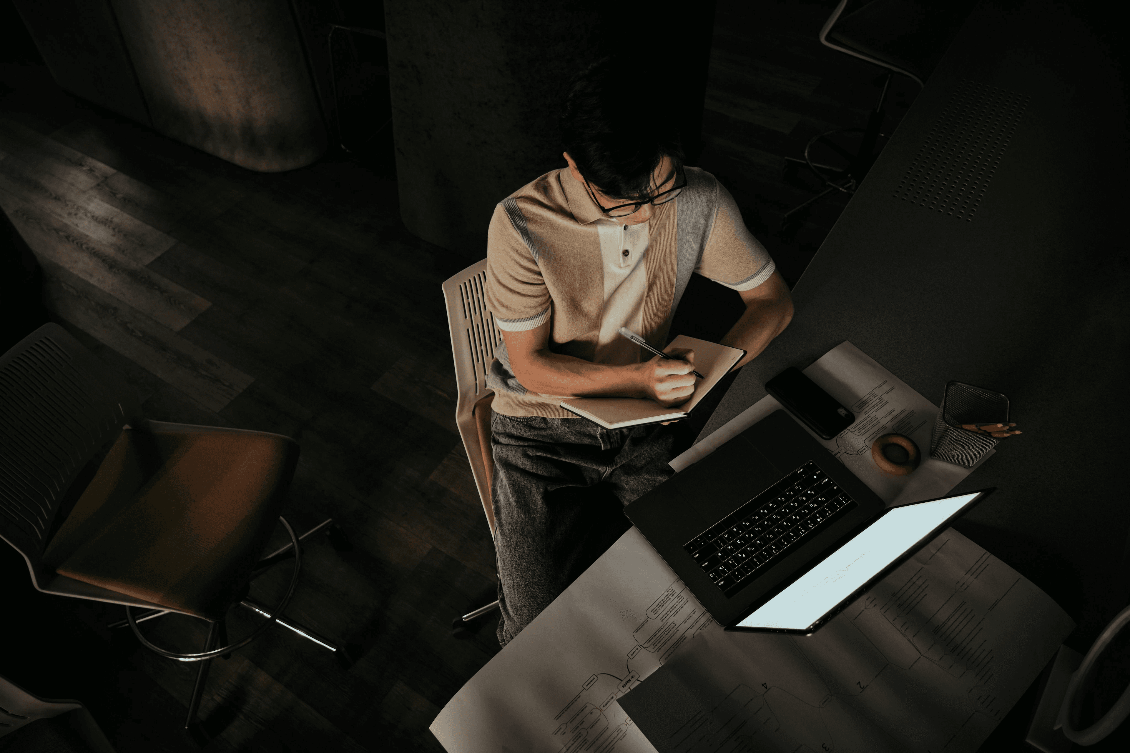 A technical professional working through plans at a laptop